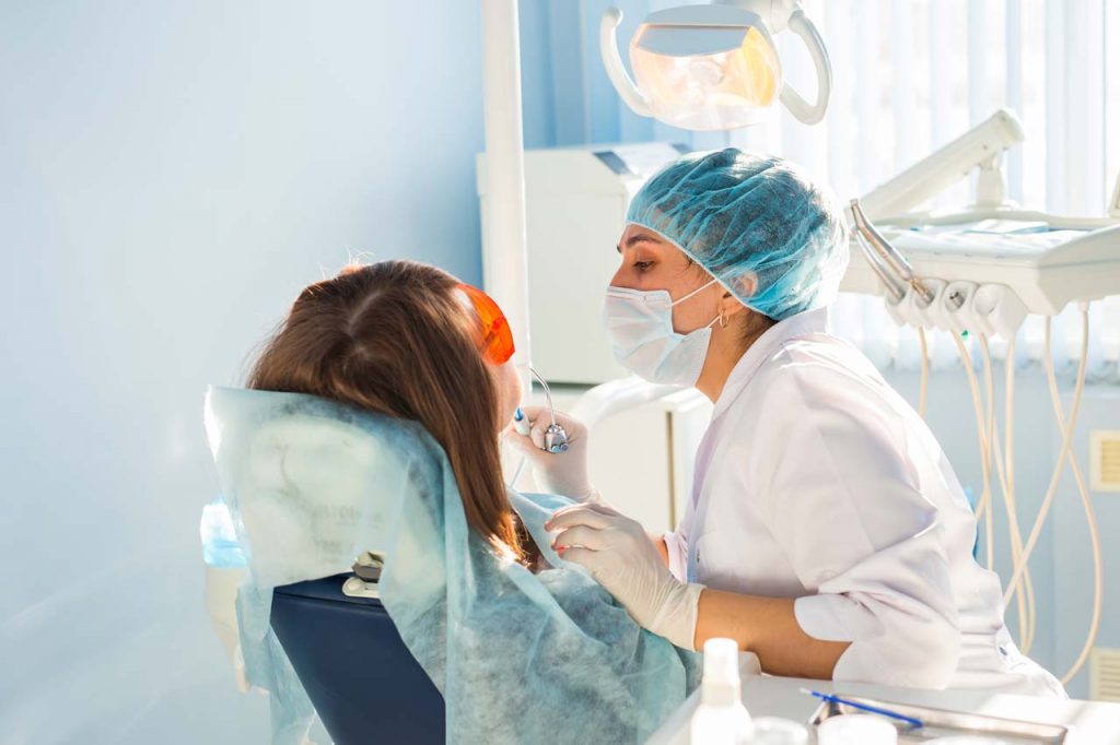 Female dentist treating young woman