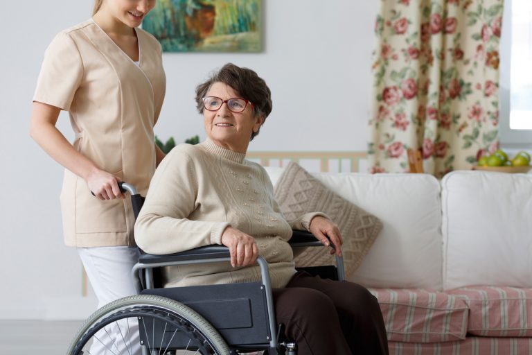 Old woman on wheelchair and her nursing assistance