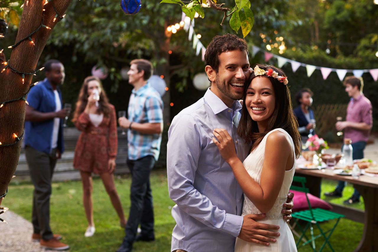 Portrait Of Couple Celebrating Wedding With Backyard Party