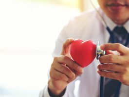 doctor holding hands with red heart in clinic office, Healthy lifestyle concept